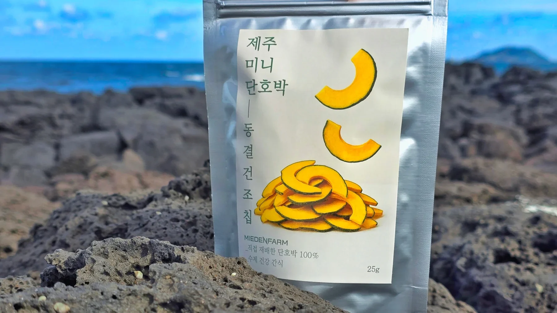 현무암 위에 놓인 제주 미니 단호박 동결건조칩 봉투(미에덴팜 직접 촬영)