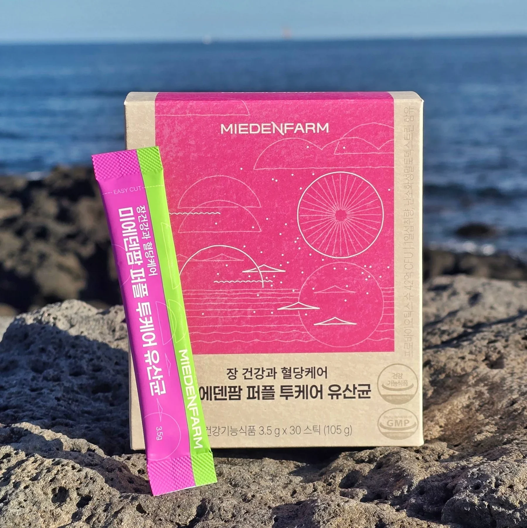 제주 바다 앞 퍼플 투케어 유산균 상자와 스틱(미에덴팜 직접 촬영)